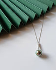 Qlassico pendant necklace from the Celestial Capsule, featuring a round peacock-coloured Tahitian pearl set in 18K white gold.