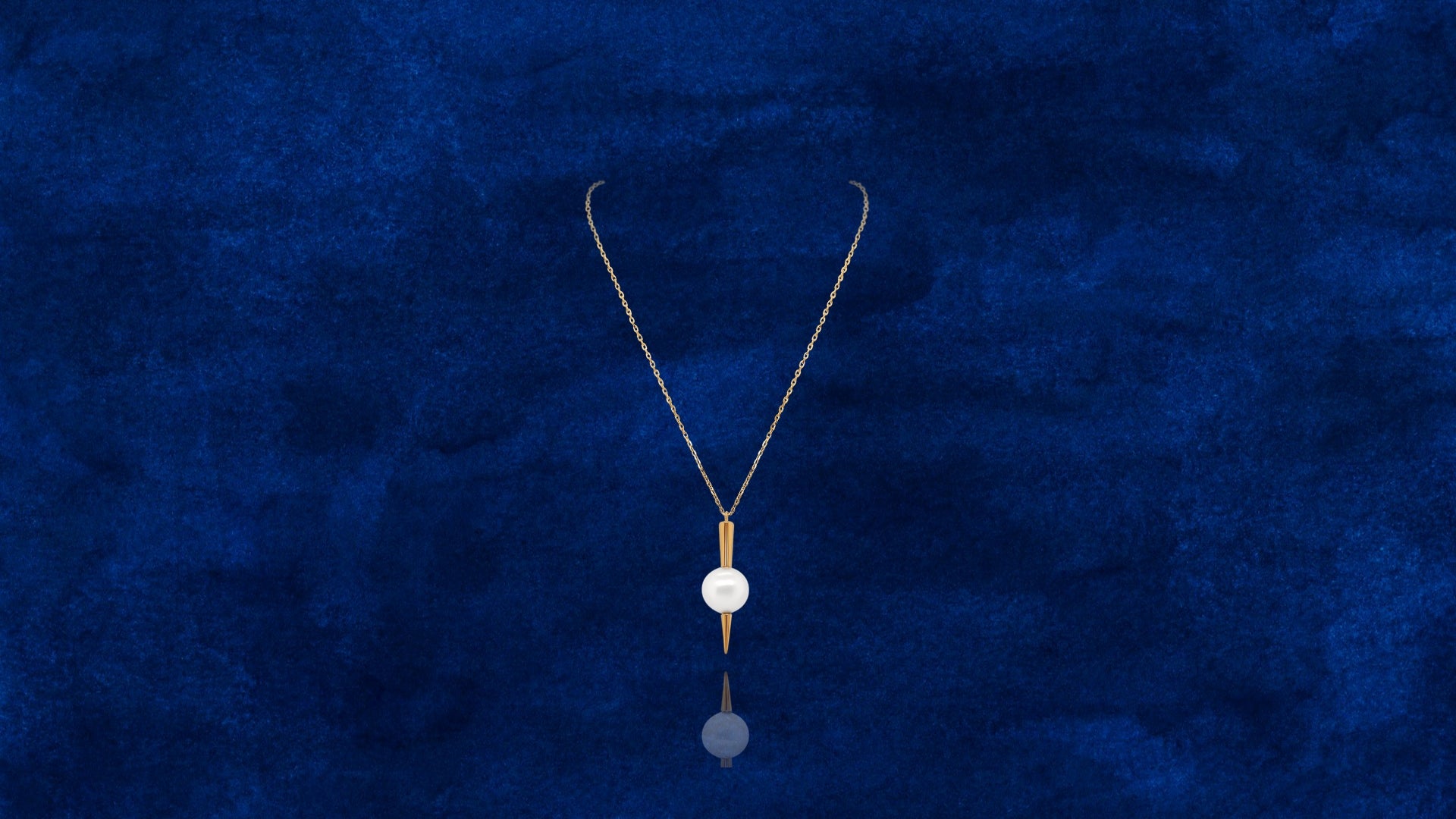 Qlassico pendant necklace from the Celestial Capsule, featuring a round Akoya pearl set in 18K yellow gold with a sculptural pointed design.