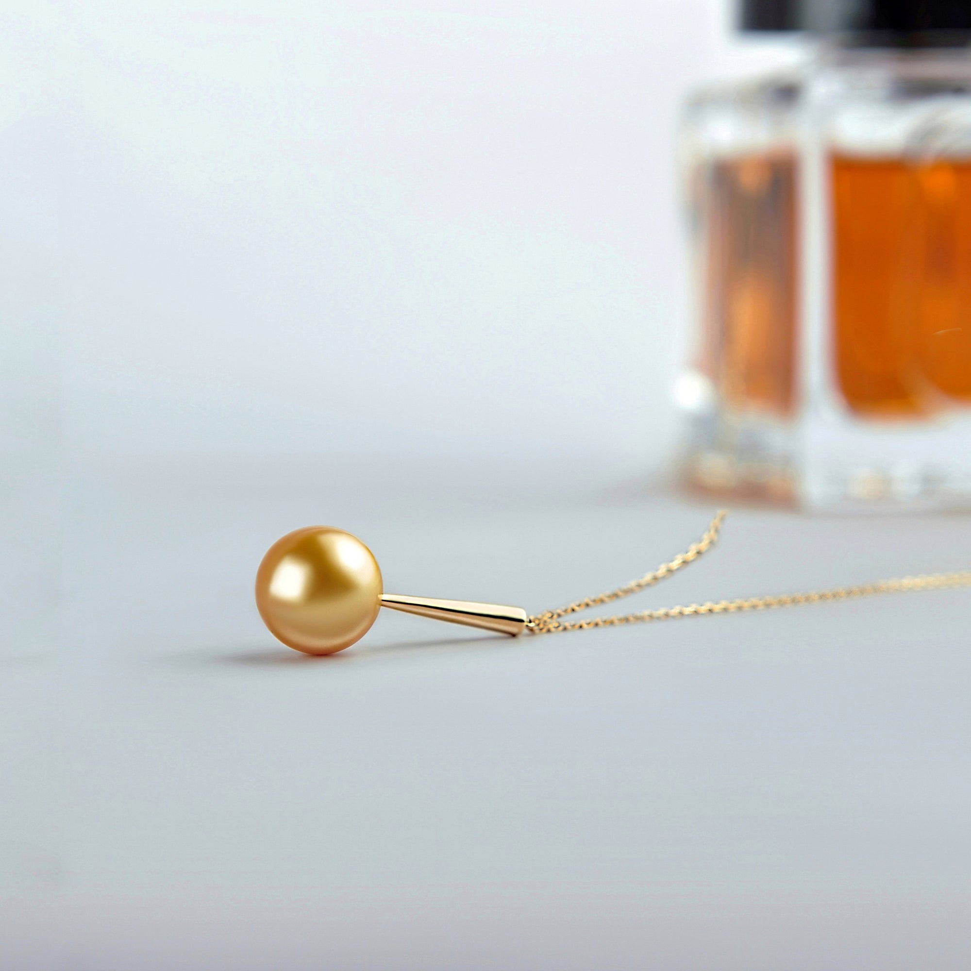 Qlassico pendant necklace from the Celestial Capsule, featuring a round golden South Sea pearl set in 18K yellow gold.