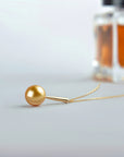 Qlassico pendant necklace from the Celestial Capsule, featuring a round golden South Sea pearl set in 18K yellow gold.