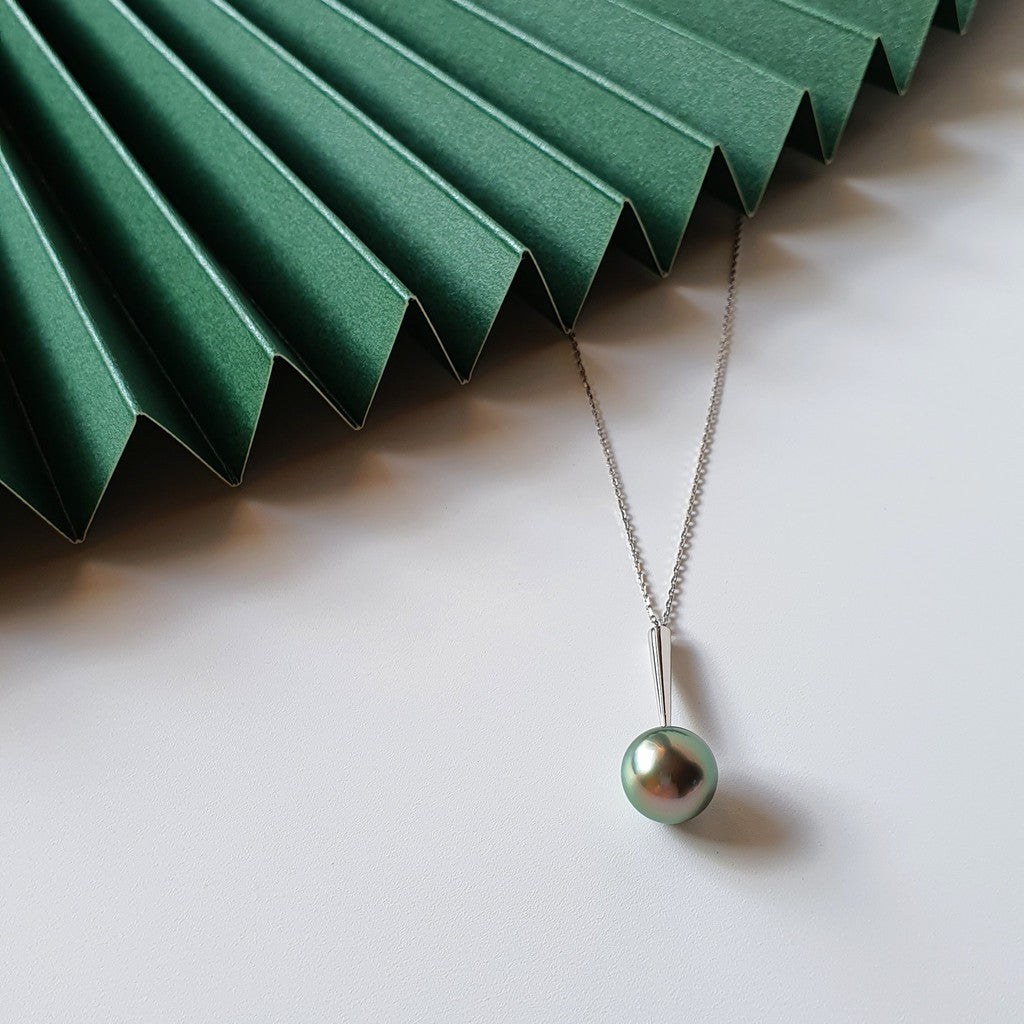 Qlassico pendant necklace from the Celestial Capsule, featuring a round peacock-coloured Tahitian pearl set in 18K white gold.