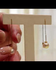 Qlassico dangling earrings from the  Celestial Capsule, featuring a pair of round Akoya pearls set in 18K yellow gold.