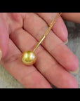 Qlassico pendant necklace from the Celestial Capsule, featuring a round golden South Sea pearl set in 18K yellow gold.