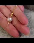 Qlassico pendant necklace from the Celestial Capsule, featuring a round Akoya pearl set in 18K yellow gold with a sculptural pointed design.
