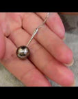 Qlassico pendant necklace from the Celestial Capsule, featuring a round peacock-coloured Tahitian pearl set in 18K white gold.