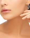 Model wearing a pair of Qlassico diamond hoop earrings, featuring natural diamonds set in 14K white gold.